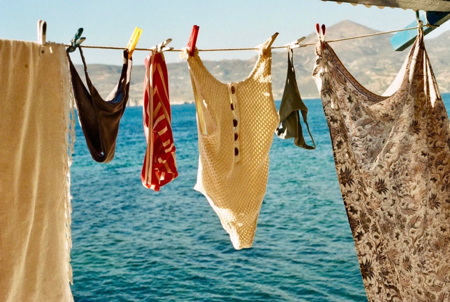 Vintage swimsuits drying on a line above the sea